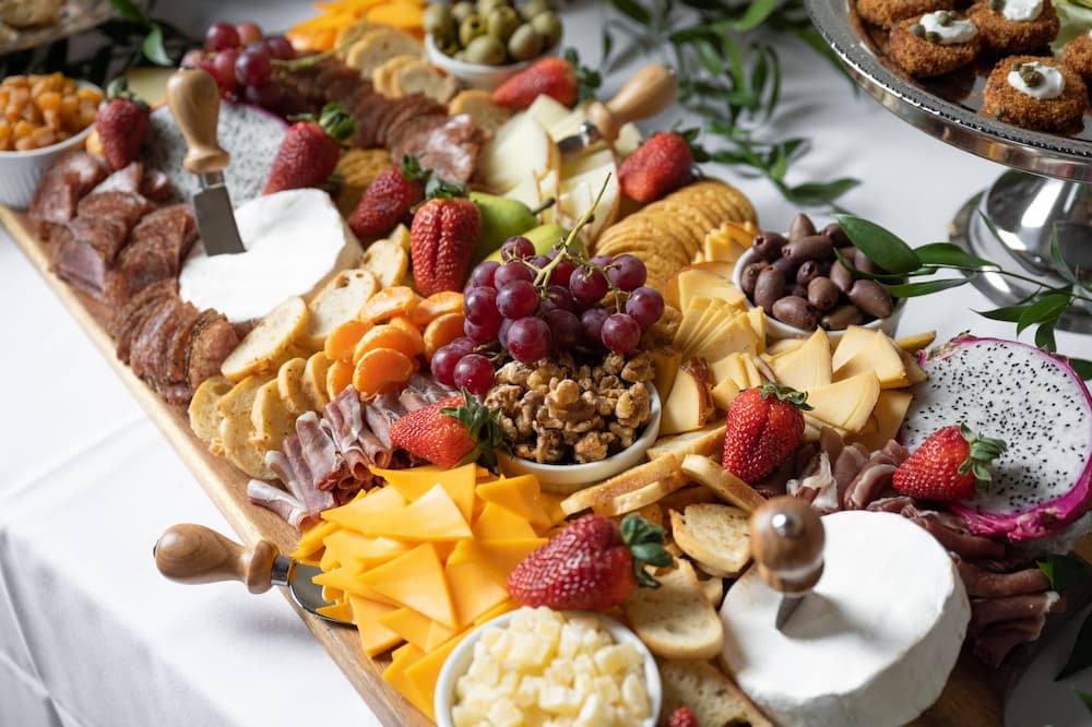Cheese, meat, and a fruit platter served with all types of dips and wine